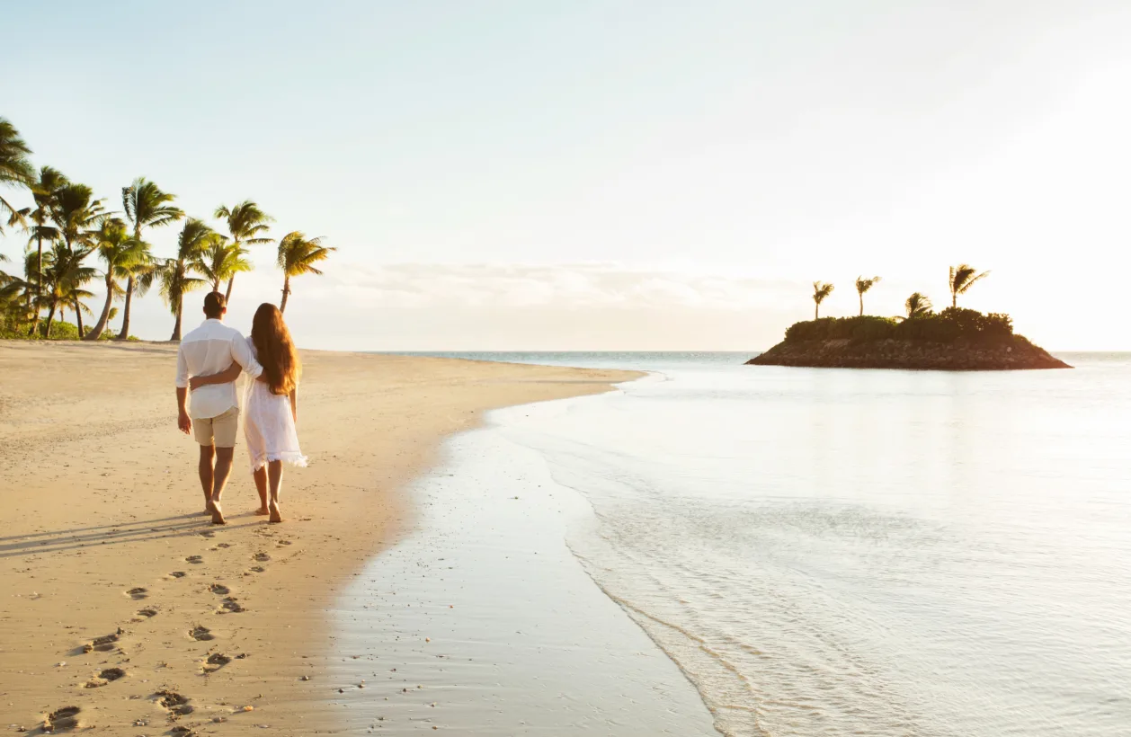 couple leaving footprints in sand at Six Senses Fiji unique honeymoon destination